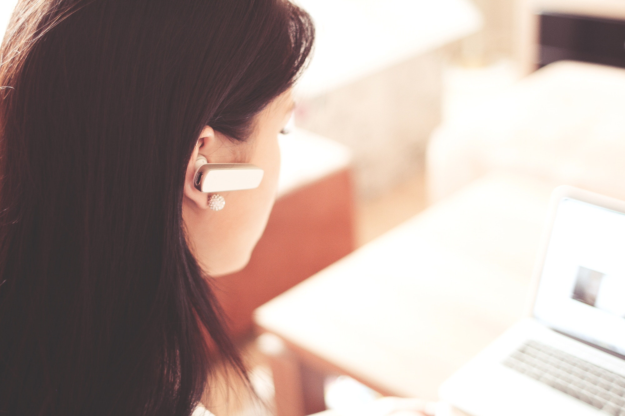 Frau mit Headset vor Bildschirm