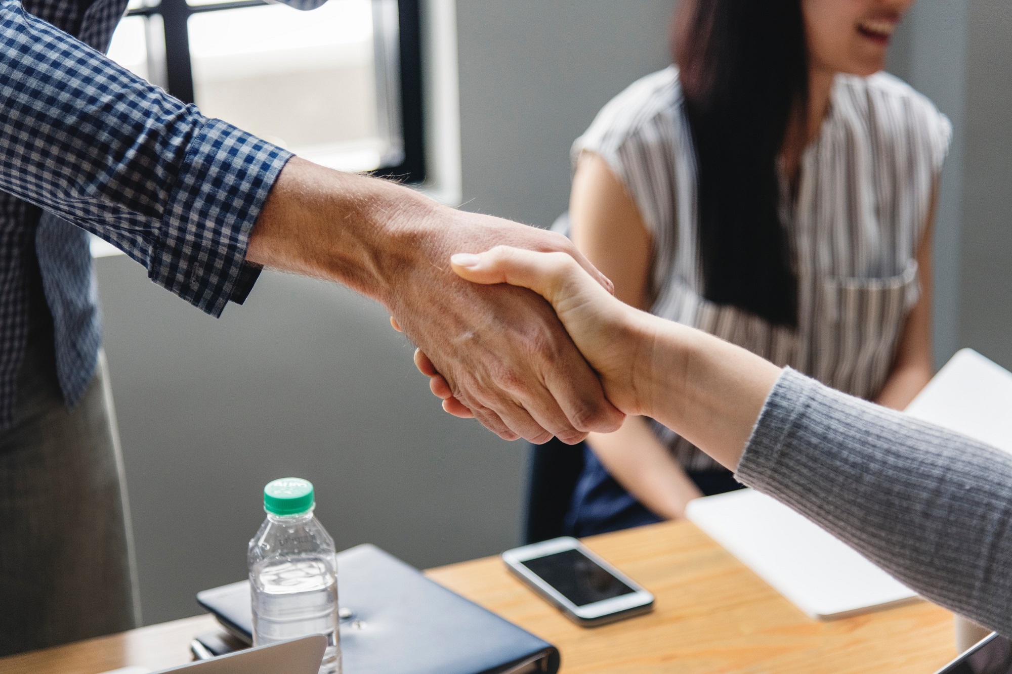 shake hands über einen Tisch hinweg